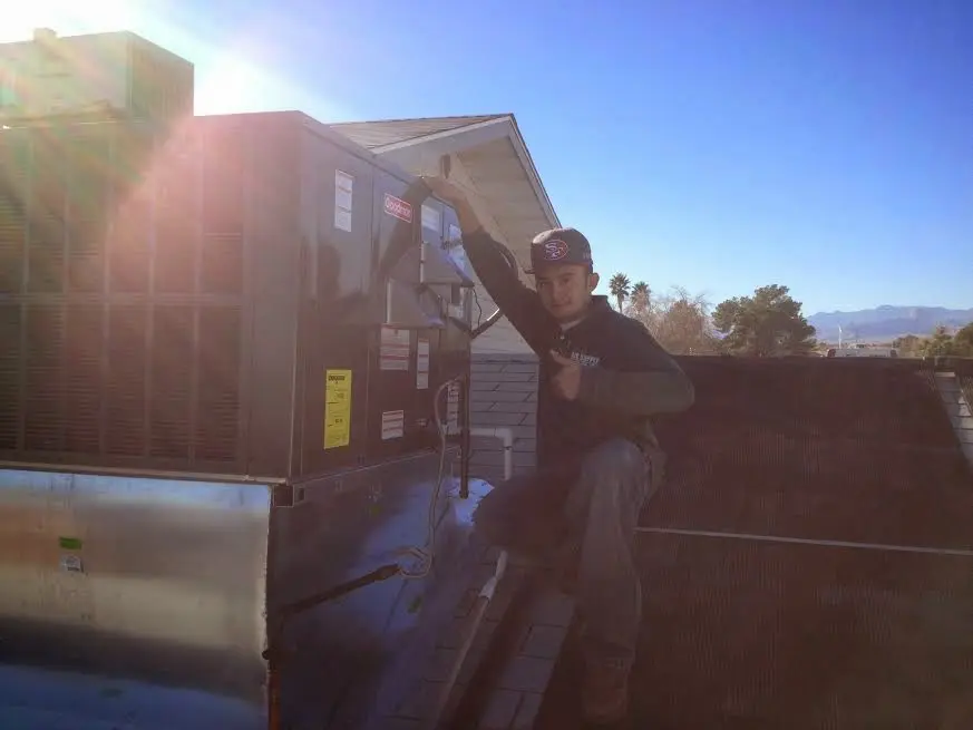 HVAC technician performing Boiler Repair on a rooftop unit in Hamburg